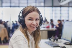 happy student with headphones and computer in university